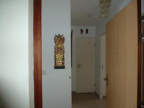 a hallway with a clock hanging on the wall at appartement les pieds dans l'eau dans résidence de standing in Le Diamant