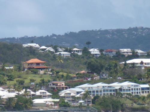 a group of houses on top of a hill at appartement les pieds dans l'eau dans résidence de standing in Le Diamant