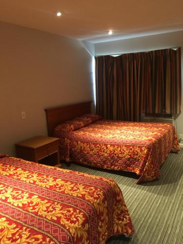 a hotel room with two beds and a window at Century Inn at LAX in Inglewood