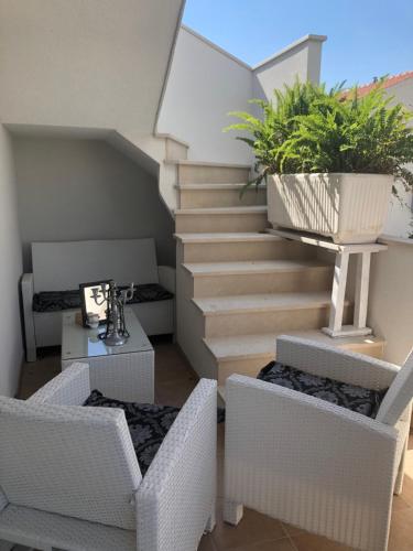 a room with chairs and a staircase with a plant at Casa di Lavanda in Hvar