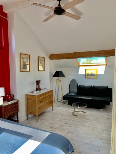a living room with a couch and a ceiling fan at La gentilhommiere de Saumur in Saumur