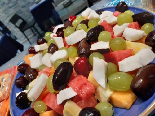 a blue plate of food with grapes and cheese at Hotel Darsena in Pozzuoli