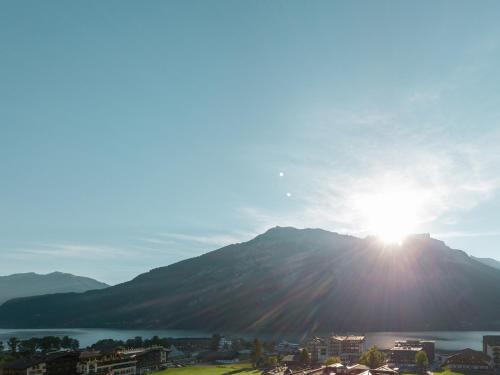 a view of the sun shining on a mountain at Hotel Auszeit in Pertisau