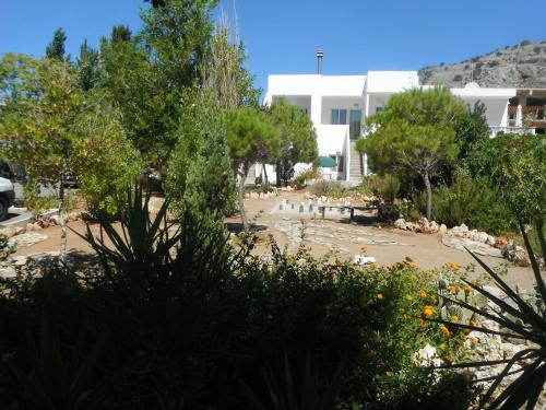 a garden in front of a white building at Mandorla Apartments in Lardos