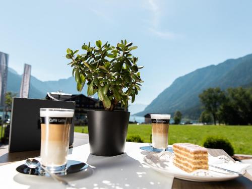 a table with two glasses of beer and a piece of cake at Hotel Auszeit in Pertisau