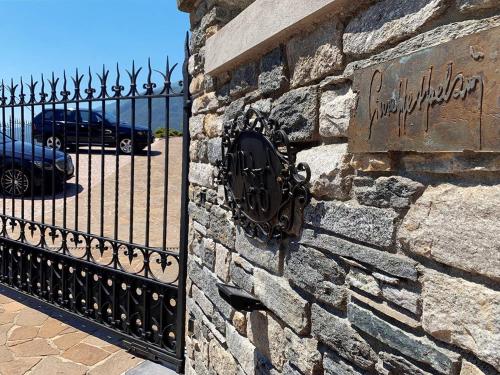 un muro in pietra con un cancello in ferro battuto di Villa Ago Luxury Apartments & Studios a Gravedona