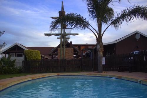 a swimming pool in front of a church with a cross at Bay Cove Inn in Jeffreys Bay