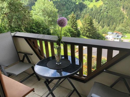 a vase with a flower on a table on a balcony at Gschlössle Ferienwohnungen in Jerzens