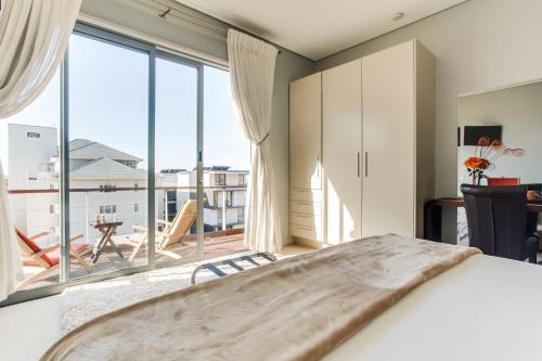 ケープタウンにあるThe One 8 Hotel in Green Point - Solar Powerのベッドと大きな窓のある寝室