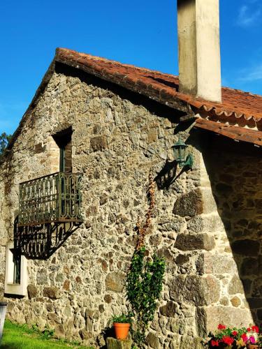 a stone building with a window and a balcony at O Lughar Darriba Fogar Natural in Gallardo