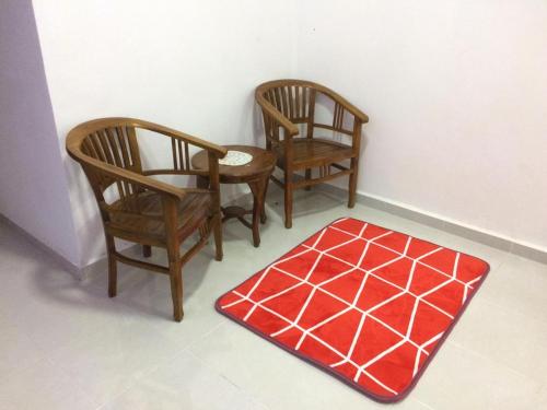 Sesuci Murni Homestay في تاناه ميراه: كرسيين وسجادة حمراء في الغرفة