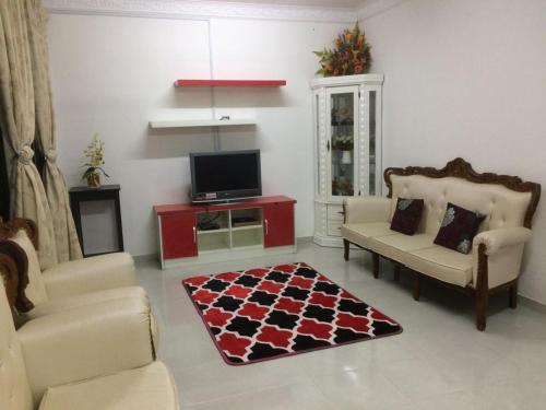 a living room with two chairs and a tv at Sesuci Murni Homestay in Tanah Merah