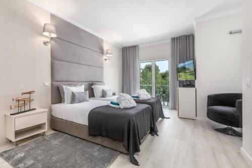 una stanza d'albergo con due letti e una sedia di D_Loft Ocean ad Albufeira
