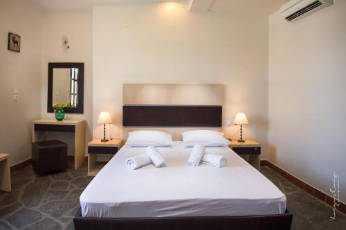 a bedroom with a large white bed with two lamps at Castro Sunset Stories in Neos Marmaras