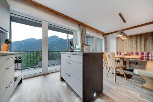 a kitchen with a table and a dining room with a view at Alpen Air exklusive Apartments in Bad Reichenhall