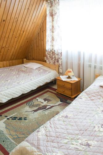a bedroom with two twin beds and a table at Willa Irys in Bukowina Tatrzańska