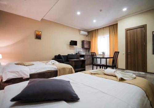 a hotel room with two beds and a living room at Hotel Nabadi in Tbilisi City