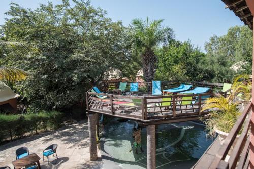 a bridge over a pool with chairs and water at Footsteps Eco-Lodge in Gunjur