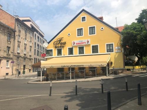 ein gelbes Gebäude an der Ecke einer Straße in der Unterkunft Apartment Tkalča in Zagreb