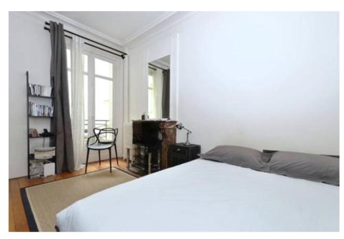 - une chambre avec un lit, une chaise et une fenêtre dans l'établissement En plein cœur de St germain dès Prés, à Paris