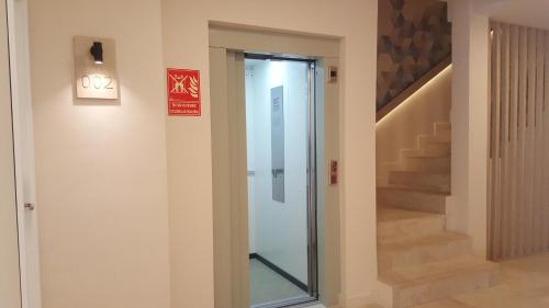 a glass door in a hallway with a staircase at Hotel Victori in Es Castell