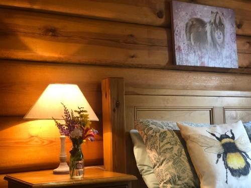 a bedroom with a bed and a table with a lamp at Log home village in Ulverston