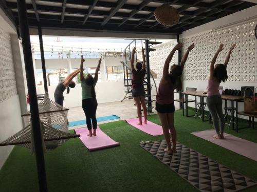 a group of people standing on mats in a yoga class at Arun Old Town in Bangkok