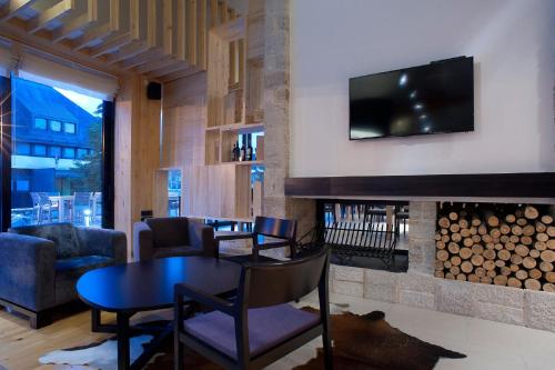 a living room with a table and a fireplace at Hotel Žabljak in Žabljak