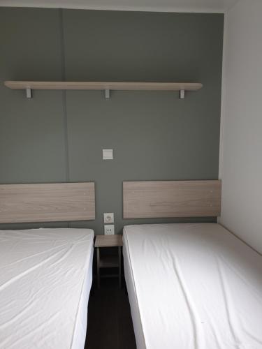 2 camas en una habitación con sábanas blancas en Altamira Camping Park en Queveda