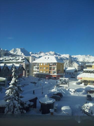 a town covered in snow with buildings and a christmas tree at Hotel Žabljak in Žabljak