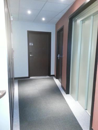 an empty room with a hallway with doors and a hallway at Hotel Vauban in Besançon