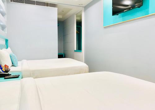 a room with two beds and a mirror at City Empire New Delhi Train Station in New Delhi