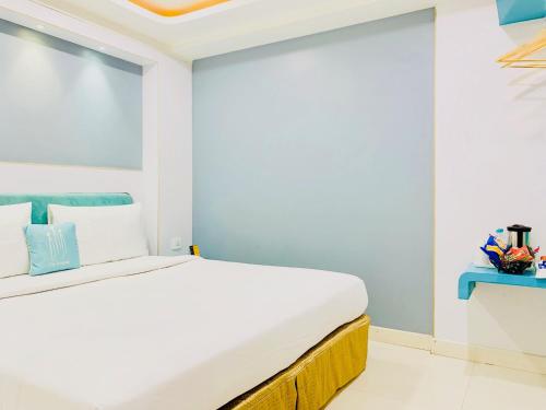 a bedroom with a white bed and a blue wall at City Empire New Delhi Train Station in New Delhi
