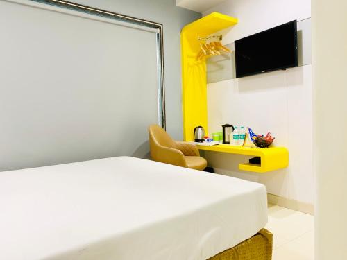 a bedroom with a white bed and a yellow shelf at City Empire New Delhi Train Station in New Delhi