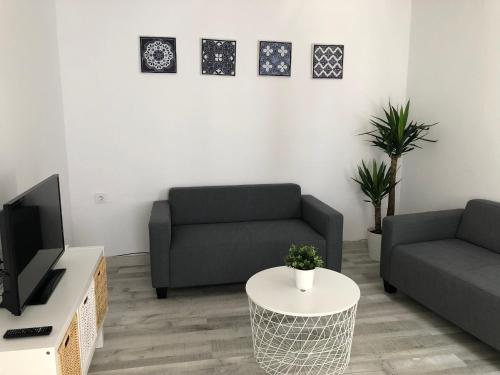 a living room with two couches and a tv at CH Apartments in Conil de la Frontera