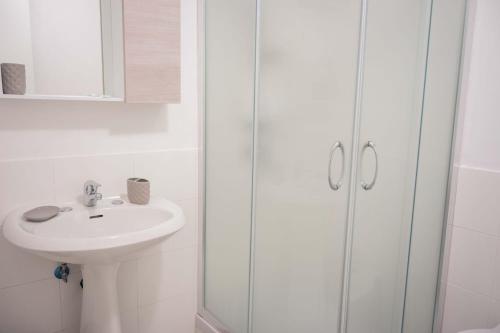 y baño blanco con lavabo y ducha. en B&B Casa dei Nonni, en Scario