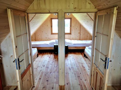 einen Innenblick auf eine Holzhütte mit 2 Betten in der Unterkunft Dorotkowy Domek in Wielowieś