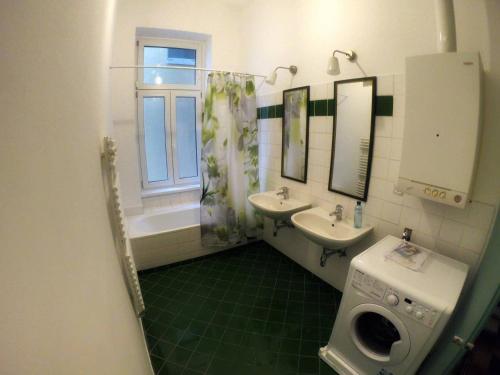 ein Bad mit 2 Waschbecken und einem Fenster in der Unterkunft Centrally-Located authentic apartment in Wien