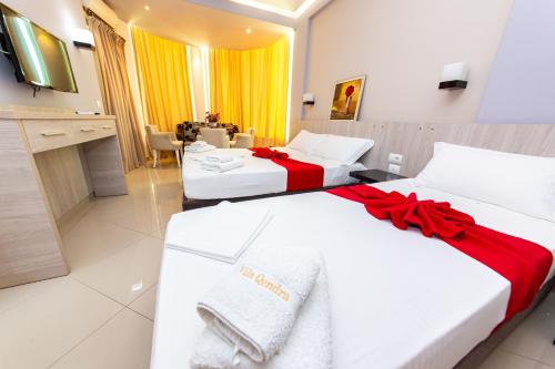 two beds in a hotel room with red accents at Hotel Villa Qendra in Ksamil