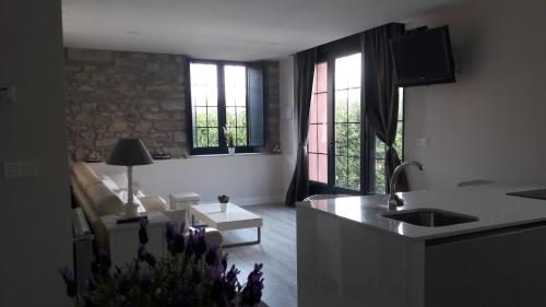 a kitchen and living room with a couch and windows at Mirador del Cantábrico in Lastres