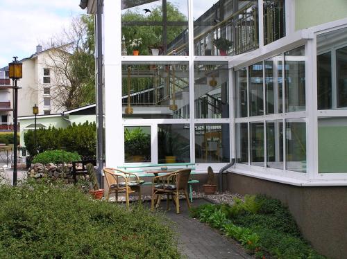 een gebouw met een tafel en stoelen ervoor bij Pension Dünenhaus in Zempin