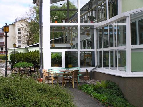 a building with a table and chairs in front of it at Pension Dünenhaus in Zempin