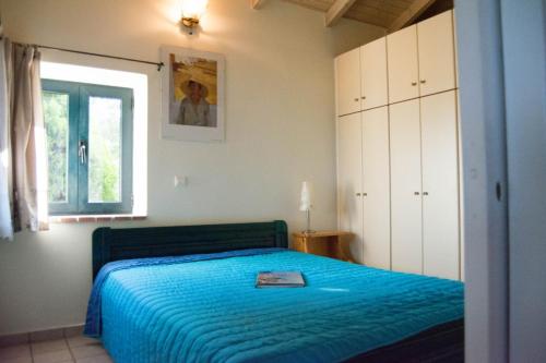a bedroom with a blue bed and a window at Villa Anna in Nafpaktos