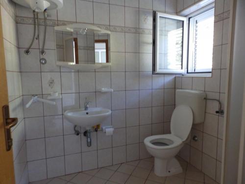 ein Bad mit einem WC und einem Waschbecken in der Unterkunft Apartment Ren - 150m from beach in Kampor
