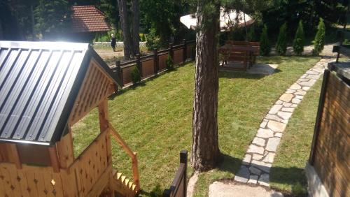 a park with a wooden staircase and a tree at Apartmani Sredojevic in Kaludjerske Bare