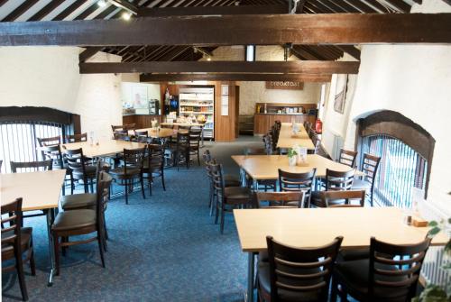 comedor con mesas y sillas en National Badminton Centre Lodge & Health Club en Milton Keynes