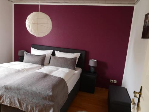 una camera con un grande letto con una parete viola di Ferienwohnung Menden a Menden