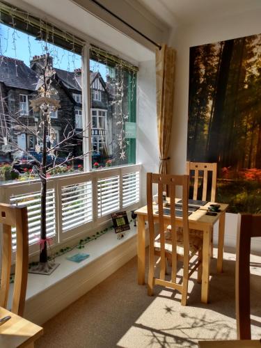 a dining room with a table and chairs and a window at The Lakes B and B in Ambleside