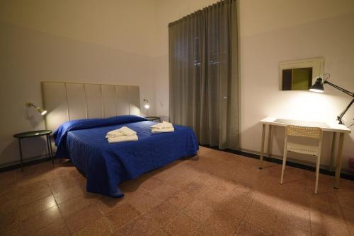 een slaapkamer met een bed, een tafel en een bureau bij TIFEO Bed & Breakfast in Catania