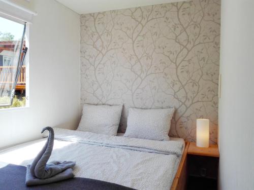 Un dormitorio con una cama con un cisne. en Mobilní dům Marbella kemp Výrovice, en Výrovice